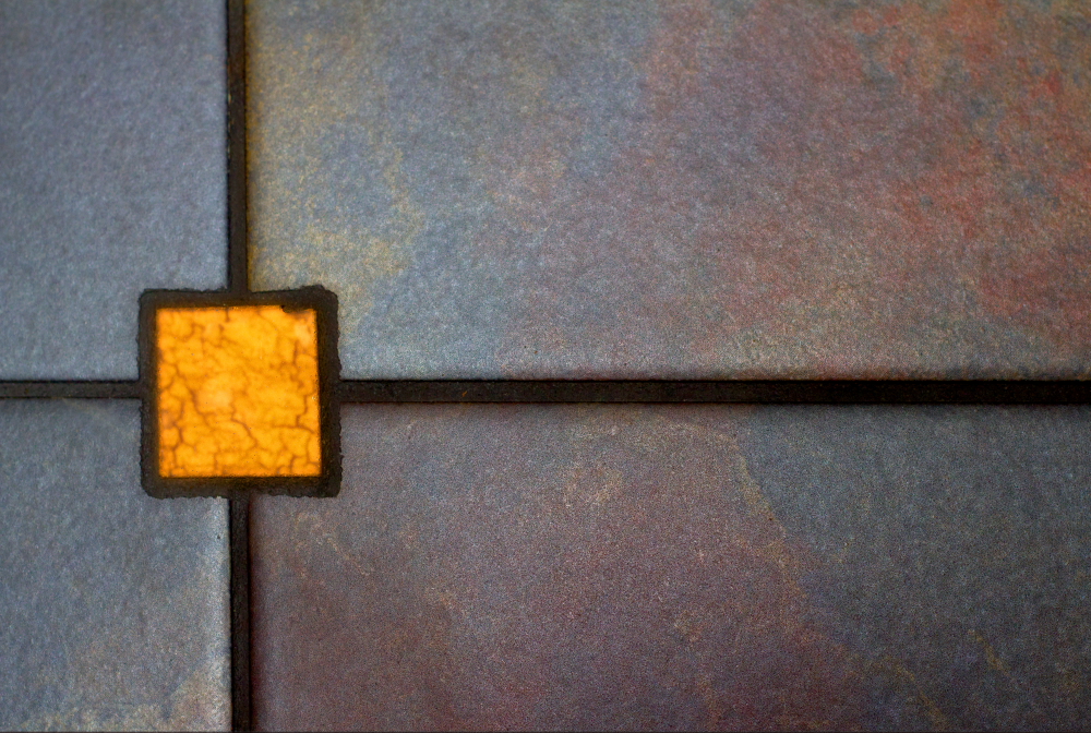 An orange square design on a tile