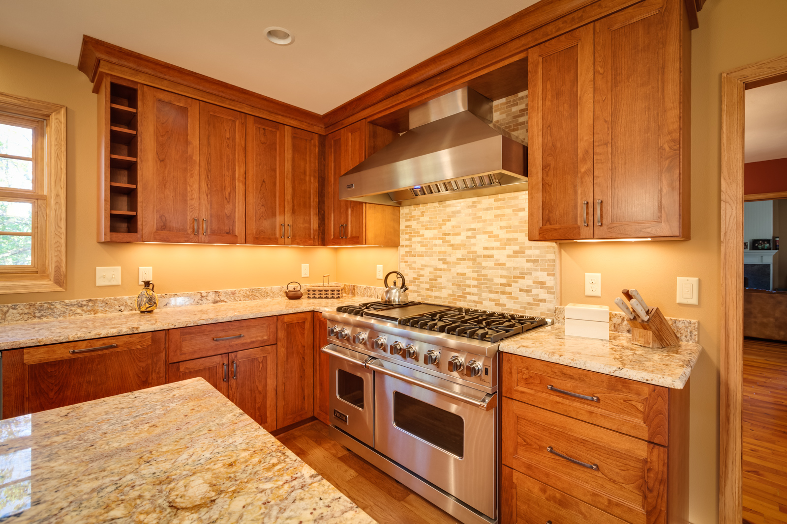 a kitchen furnished with wood cupboards and marble tabletops