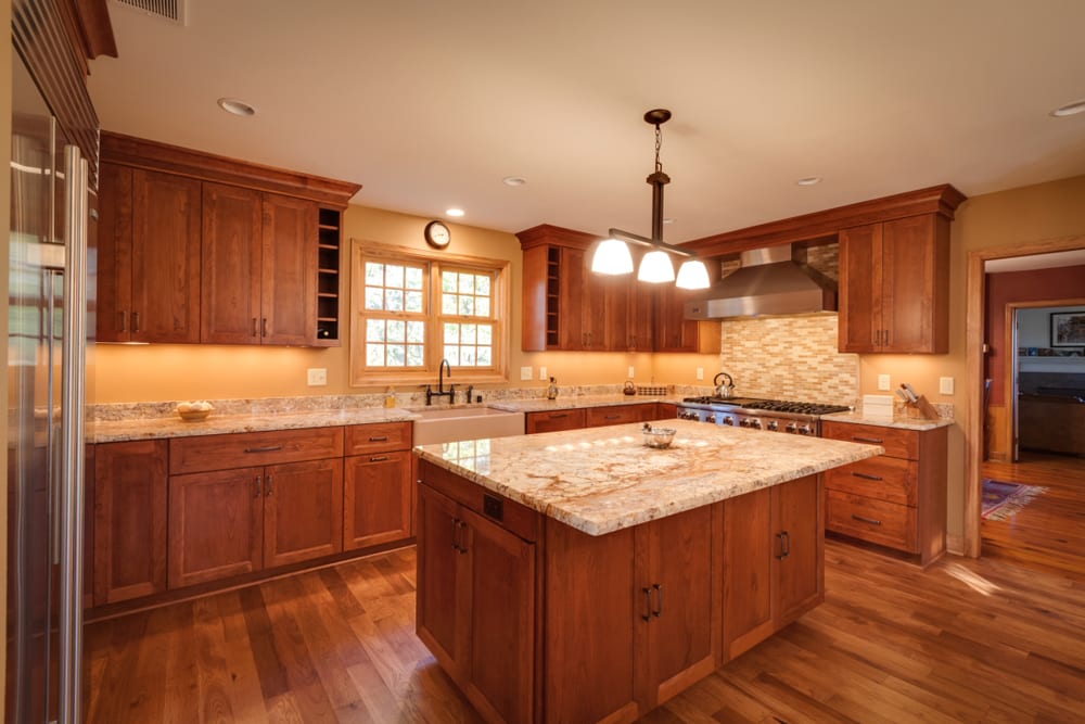 a kitchen with many wood furnishings and warm lighting